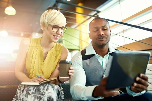 Coworkers looking at tablet- JConnelly blog- Tips for Engaging on Social Media