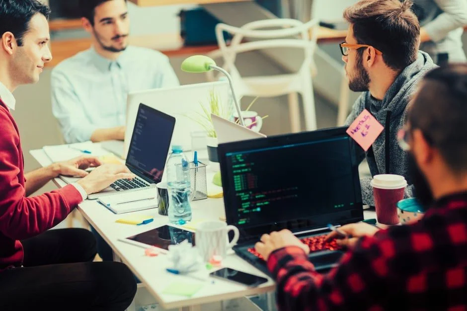 Coworkers at laptops- JConnelly blog- jargon won't build your business